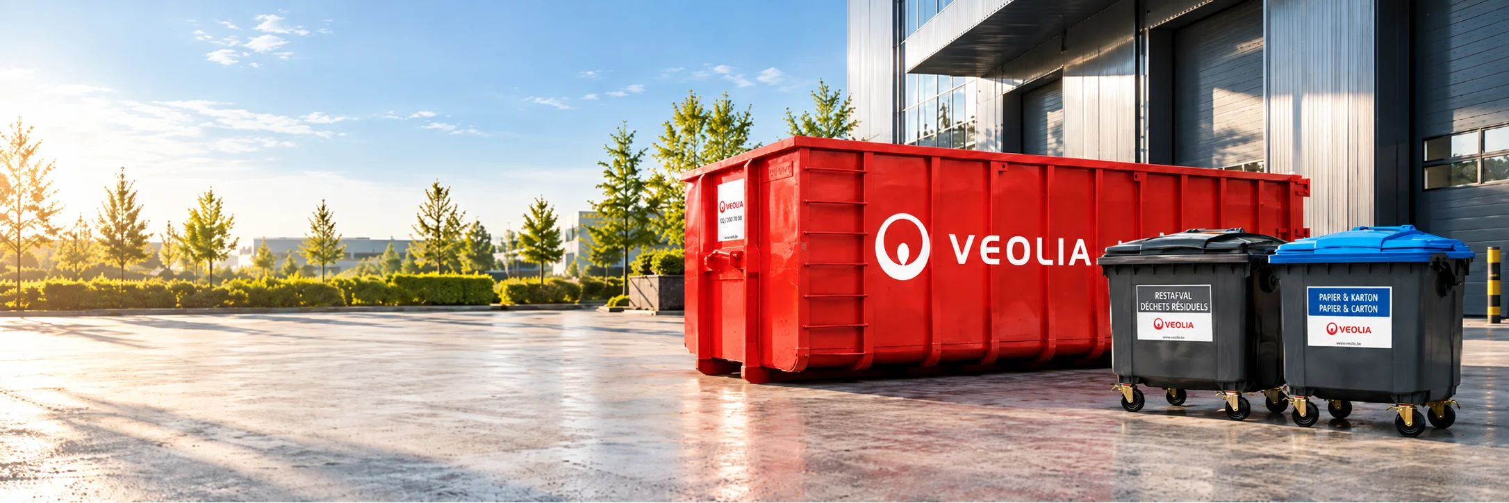 Conteneur ouvert rouge Veolia et conteneurs à roulettes pour déchets professionnels sur un site d’entreprise