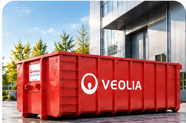 Conteneur ouvert rouge Veolia sur un site d’entreprise moderne